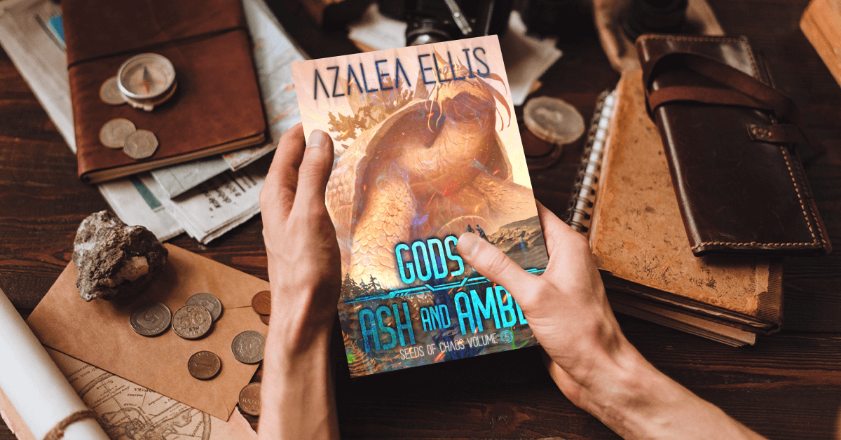 Person holding a Paperback of Gods of Ash and Amber