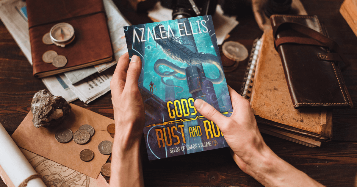 Person holding a Paperback of Gods of Rust and Ruin